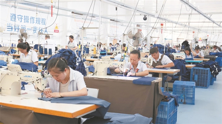 务工群众正在缝制衣服。