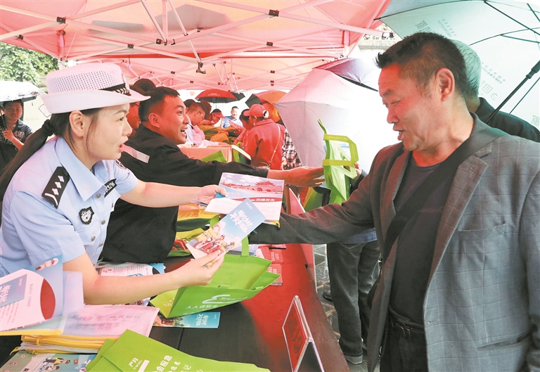 工作人员向过往市民发放宣传资料。赵娜 摄