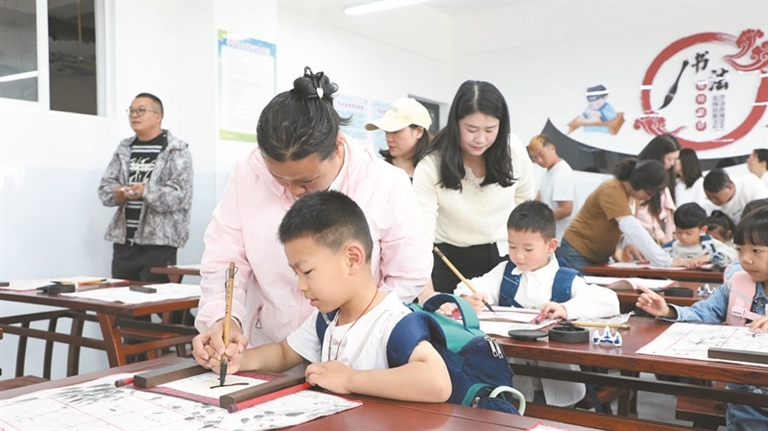 新生认真描写“人”字。周艳红 摄