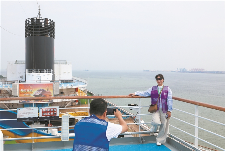 旅客在“理想号”邮轮上拍照打卡。新华社发